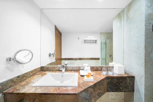 y baño con lavabo y espejo. en BelAir SunClub Cabos by Krystal Grand en San José del Cabo