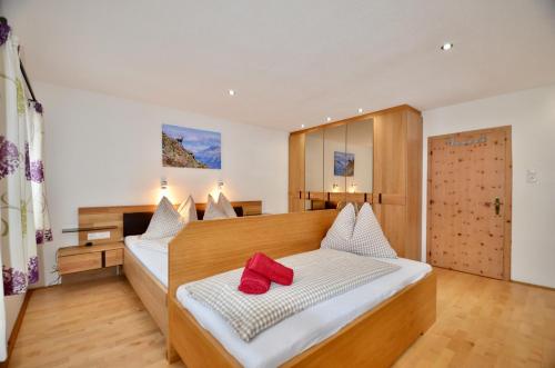 a bedroom with a bed with two red pillows on it at Ferienhaus Ban Brösign in Umhausen