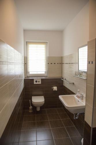 a bathroom with a toilet and a sink at Spreeidyll in Schlepzig