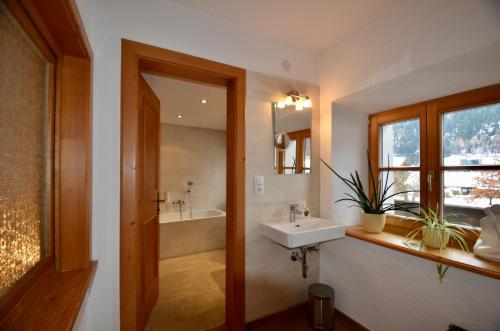 La salle de bains est pourvue d'un lavabo et d'une baignoire. dans l'établissement Ferienhaus Ban Brösign, à Umhausen