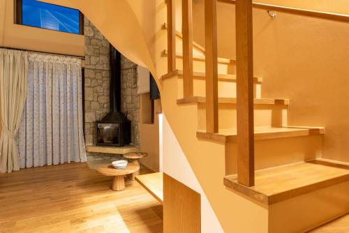 a wooden staircase in a room with a fireplace at 5 Raches Suites in Arachova