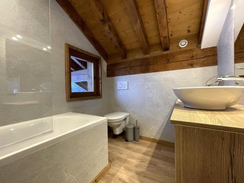 a bathroom with a sink and a tub and a toilet at Appartement Saint-Martin-de-Belleville-Les Menuires, 5 pièces, 10 personnes - FR-1-452-67 in Saint-Martin-de-Belleville