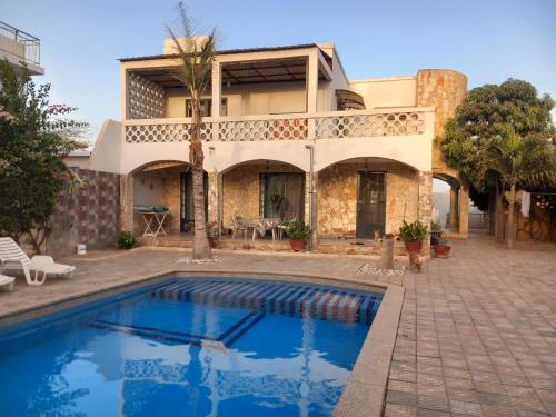 une villa avec une piscine en face d'une maison dans l'établissement Casa Kassi, à Ndéyane