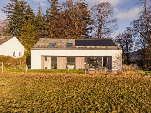 una casa con paneles solares en el techo en Tethera: Eco-Luxury Passivhaus on Ullswater, en Watermillock