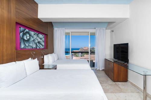 Habitación de hotel con 2 camas y TV en BelAir SunClub Cabos by Krystal Grand en San José del Cabo
