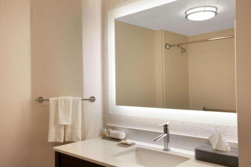 a bathroom with a sink and a large mirror at La Quinta by Wyndham Miami Airport West in Miami