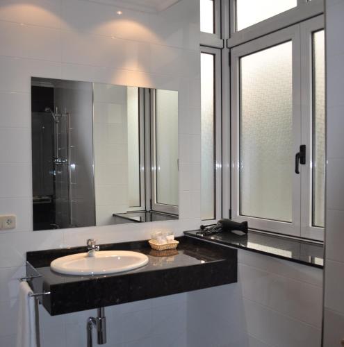 a bathroom with a sink and a mirror at Hotel Crunia I A Coruña in A Coruña