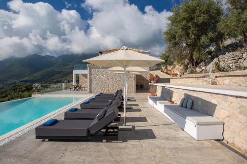 a pool with lounge chairs and an umbrella at Rachi Sea View White Villa in Episkopos