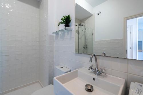 W łazience znajduje się umywalka, toaleta i lustro. w obiekcie Fee4Me Piso en primera linea en Caion w mieście Laracha
