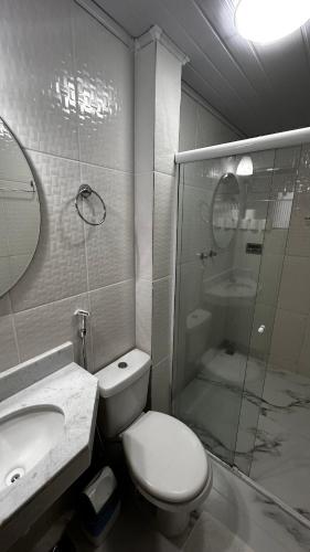 a bathroom with a toilet and a sink and a shower at Alfa Mar Pousada in Abraão