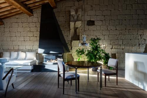 jadalnia ze stołem i krzesłami oraz ceglaną ścianą w obiekcie Palazzo Petrvs w mieście Orvieto