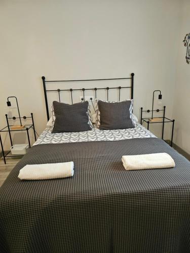 a black and white bed with two towels on it at Apartamentos La Mar in Altea