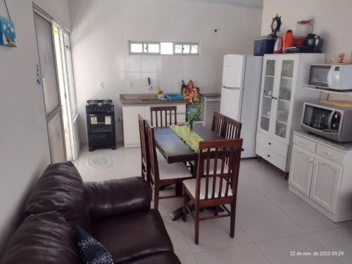 a kitchen with a couch and a table with chairs at APARTAMENTO MARISCAL in Bombinhas