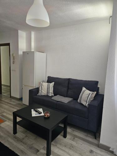a living room with a blue couch and a table at Apartamentos La Mar in Altea