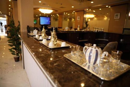 a bar in a restaurant with dishes on a counter at فندق هلا اثنين in Arar