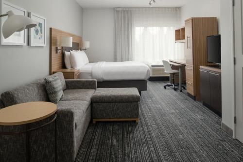奧林匹亞的住宿－奧林匹亞萬豪廣場套房酒店，酒店客房设有一张沙发和一张床