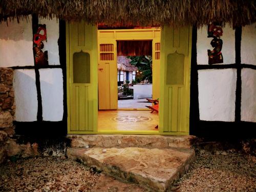 an open doorway to a house with a yellow door at Hotel y Museo Aldea Maya Toktli Orígenes - Casa Maya Del Toloque Coronado - Alberca, Wifi Starlink, Tour Museo in Izamal