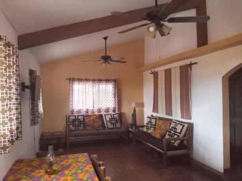 Una sala de estar con una mesa y un ventilador de techo. en Punta Pequena, en San Juanico