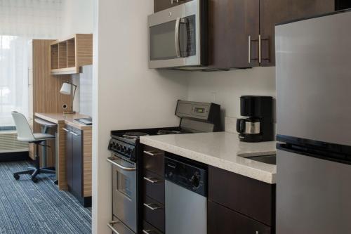 a kitchen with a refrigerator and a counter top at TownePlace Suites by Marriott Olympia in Olympia
