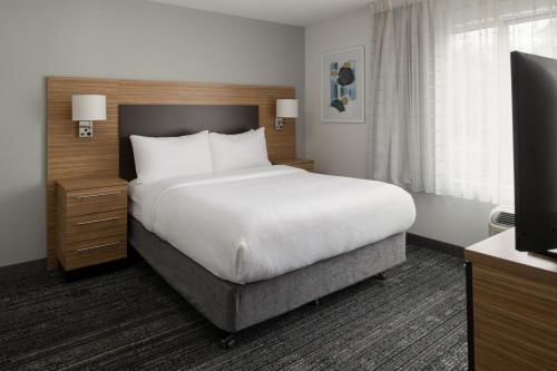 a bedroom with a large bed and a television at TownePlace Suites by Marriott Olympia in Olympia
