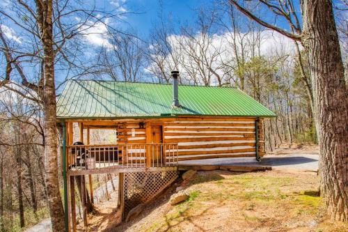 a cabin in the woods with a green roof at The Pine Knot Cabin in Sevierville