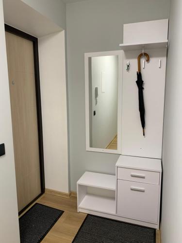 uma casa de banho com um toucador branco com um espelho e um guarda-chuva em Modern Apartment em Narva
