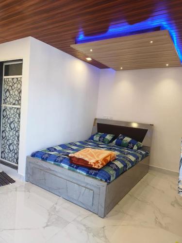 łóżko w pokoju z niebieskim światłem w obiekcie Keshavkunj The Home Stay!!! w mieście Mahabaleshwar