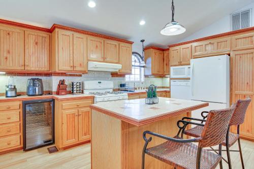 a kitchen with wooden cabinets and a white refrigerator at Canalfront Port Isabel Cottage 5 Mi to Beach! in Port Isabel