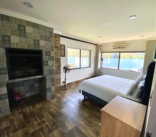 a bedroom with a large bed and a fireplace at LAKE-HOUSE CABIN in Witbank