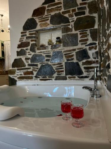 twee glazen rode wijn zittend op een bad bij ΠΑΛΙΟ ΧΩΡΙΟ in Palaios Panteleimon
