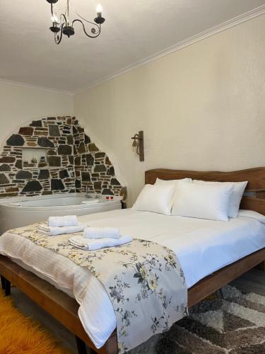 een slaapkamer met een bed en een stenen muur bij ΠΑΛΙΟ ΧΩΡΙΟ in Palaios Panteleimon