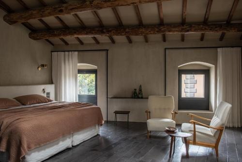 een slaapkamer met een bed en 2 stoelen. bij Palazzo Petrvs in Orvieto