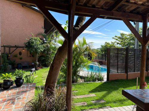 a backyard with a palm tree and a swimming pool at Namaste Flats Praia do Rosa in Imbituba