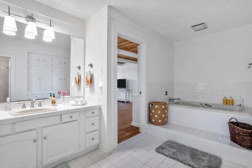 a white bathroom with a tub and a sink at 3 Bedroom House on the Lake in Lake Charles