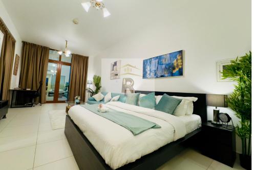 a large bedroom with a large bed with blue pillows at Palm View East Jumeira - Studio Apartment in Dubai
