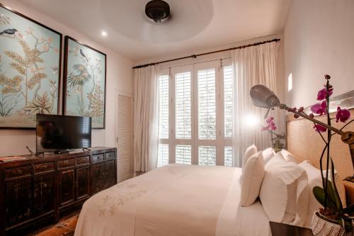 a bedroom with a bed and a tv and a window at Amarla Boutique Hotel Cartagena in Cartagena de Indias