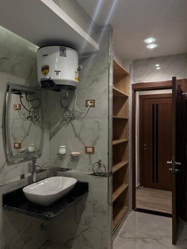y baño con lavabo y secador de pelo. en شقه فندقيه مستقله بالشيخ زايد en Sheikh Zayed