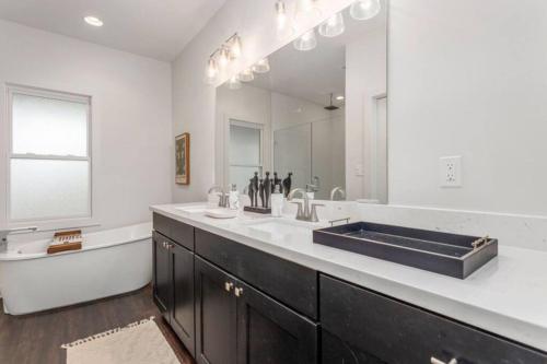 a bathroom with a sink and a large mirror at Downtown 3 bedroom Townhouse in Lake Charles