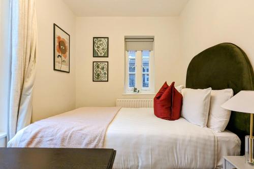 a bedroom with a large white bed with red pillows at Be London - Farringdon Apartments in London