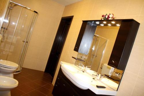 a bathroom with a sink and a shower and a toilet at Ambrózia Étterem és Panzió in Kazincbarcika