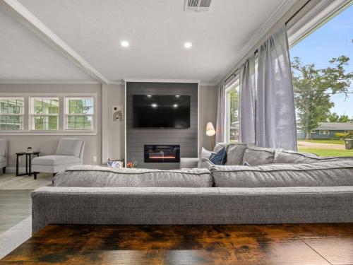 a living room with a large couch and a fireplace at Beautiful 3 Bedroom Home in Lake Charles