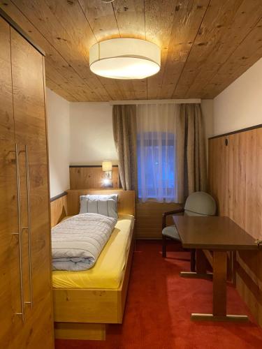a small bedroom with a bed and a table at Appartment Thumerhof Wildschönau in Niederau