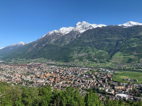 an aerial view of a town in front of mountains at La stanza dei segreti in Aosta