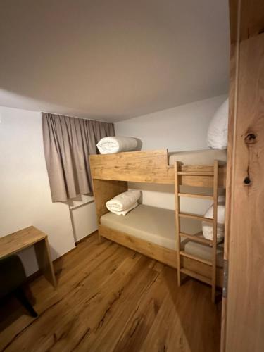 Mały pokój z łóżkiem piętrowym i biurkiem w obiekcie Ferienwohnung Krallinger w mieście Wenns