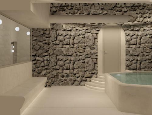 a room with a stone wall and a bath tub at YeeOn Living-Well Boutique City Hotel Gythio in Gythio