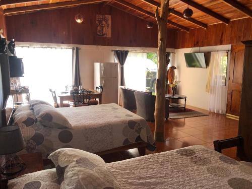 a bedroom with four beds and a room with a kitchen at Casa Haydee Monteverde in Monteverde Costa Rica