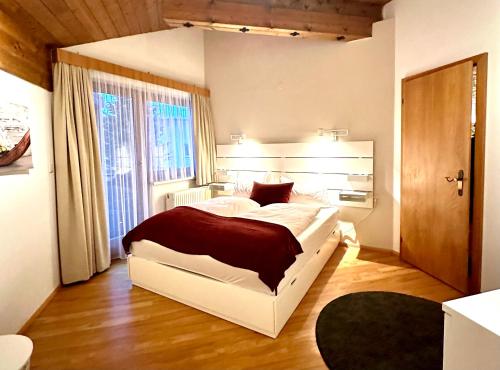 Un dormitorio con una gran cama blanca y una ventana en Landhaus Solaris en Leutasch