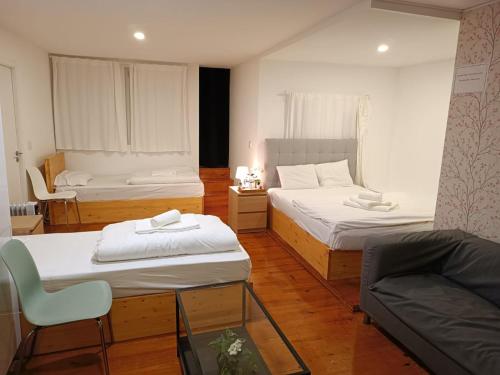 a small room with two beds and a couch at Sylhet BNB in Lisbon