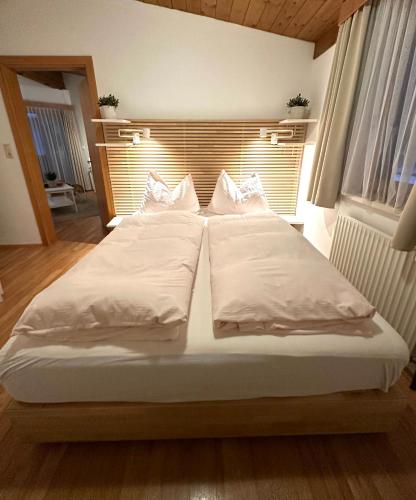 a bed with two pillows on it in a room at Landhaus Solaris in Leutasch