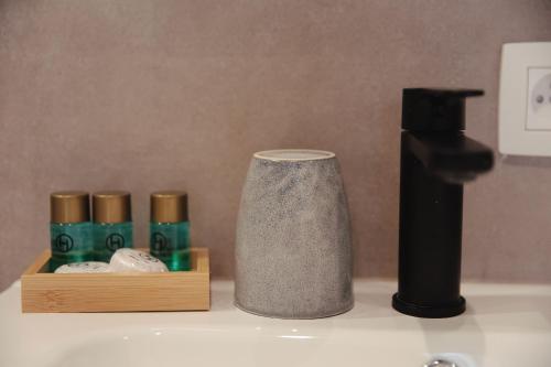 a bathroom sink with a bottle of soap and a faucet at MD luxury in Bruges